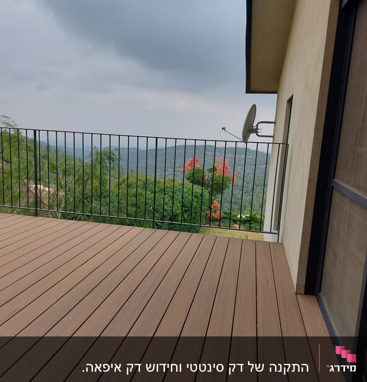 דק עץ חום עם מעקה מתכת ונוף ירוק